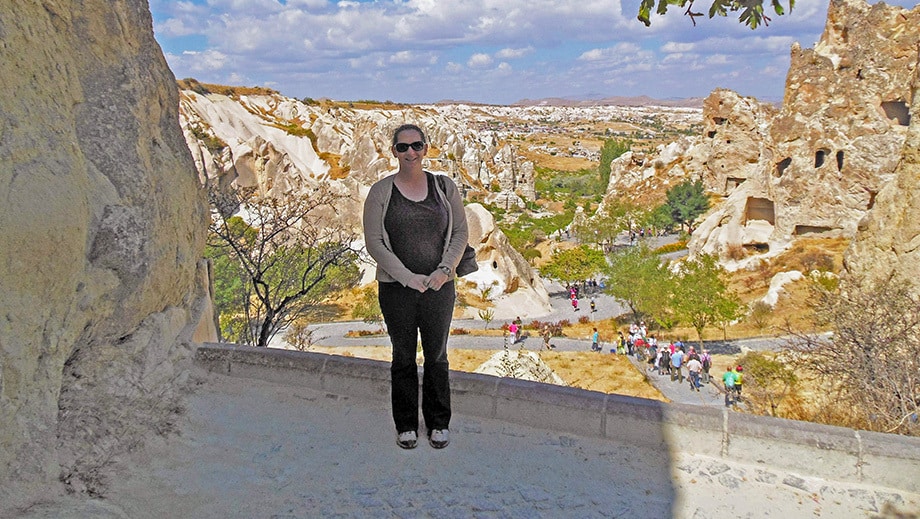 InterExchange team member, Lynne, poses on ledge overlooking Cappadocia, Türkiye.