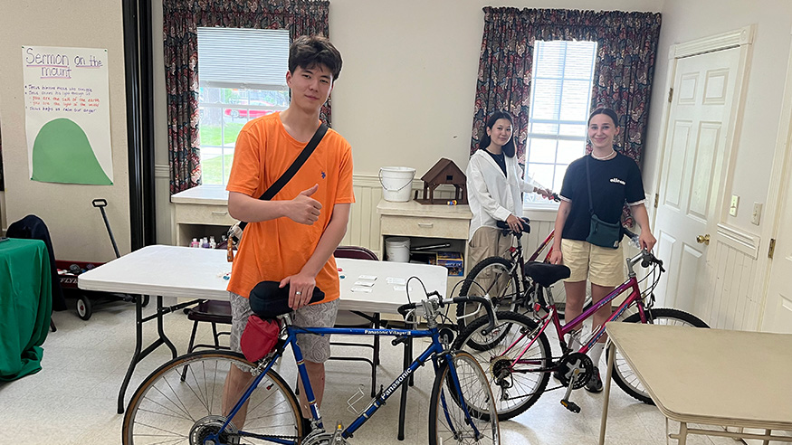 Work & Travel USA participants Alibek, Aisha, and Yana won free bicycles at the Welcome Orientation in Lake George, NY on July 10, 2024